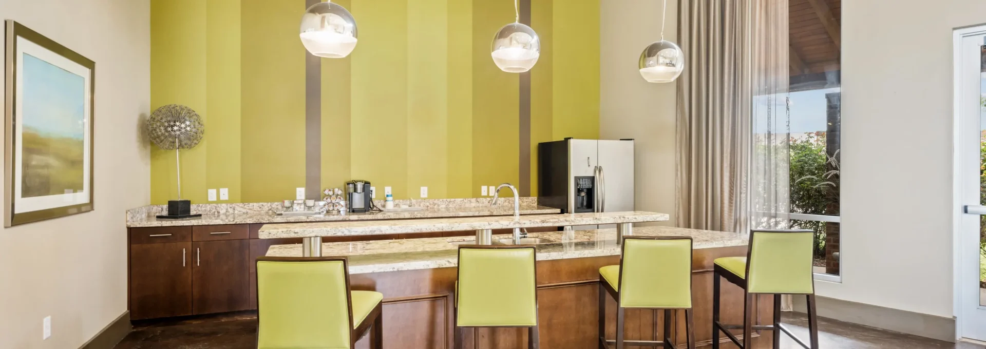 a kitchen with a large island and green walls at The  BLVD