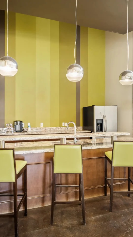 a kitchen with a large island and green walls at The  BLVD