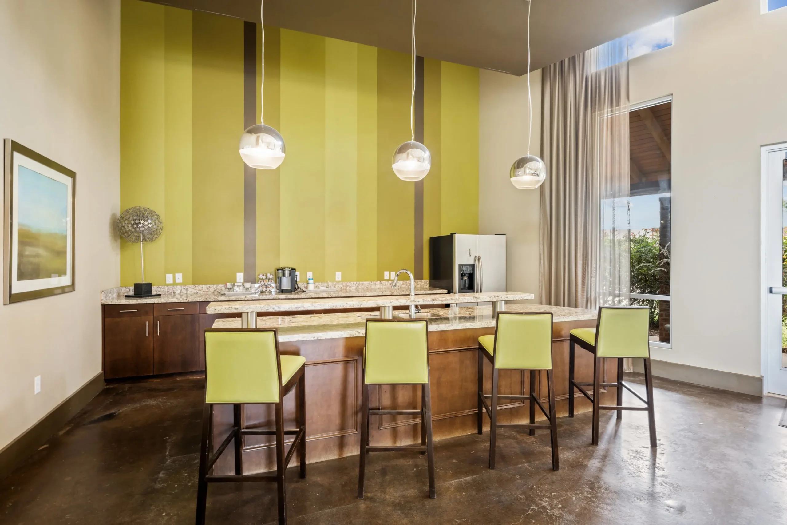 a kitchen with a large island and green walls at The  BLVD