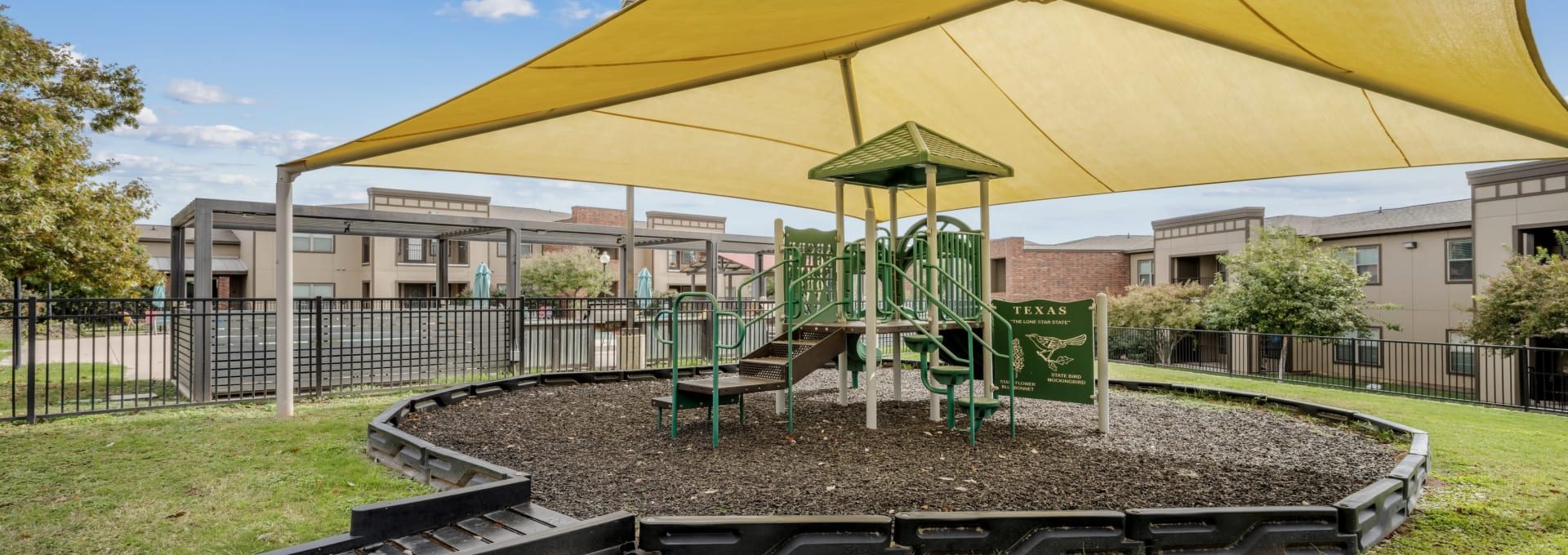 a playground area with a yellow canopy and a slide at The  BLVD