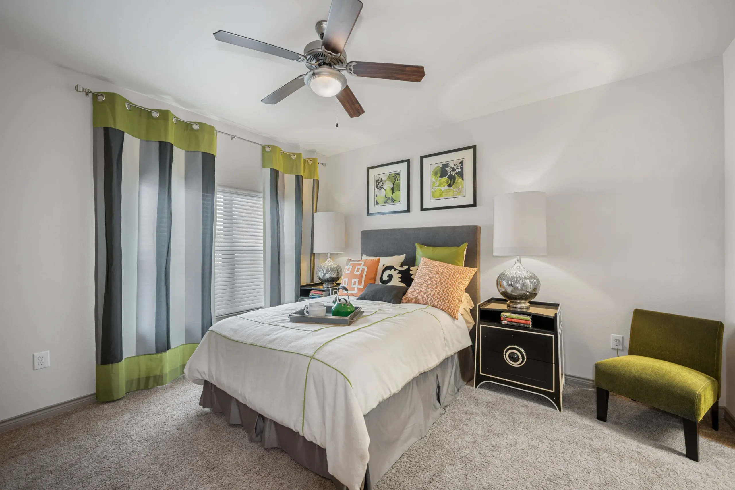 a bedroom with a bed, dresser, and ceiling fan at The  BLVD